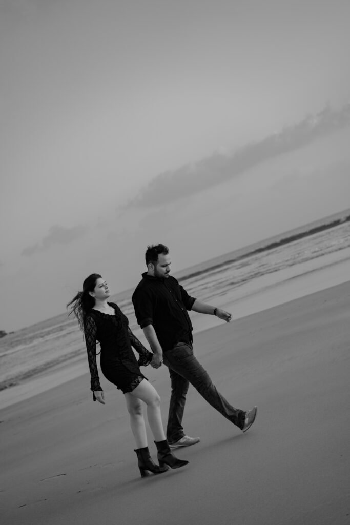 1. Couple smiling together with red roses during their romantic pre-wedding photoshoot in Diu by Memories by TK Solanki.