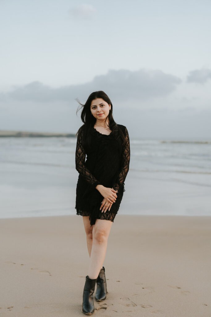 Woman holding red roses by the sea during a romantic pre-wedding photoshoot in Diu.