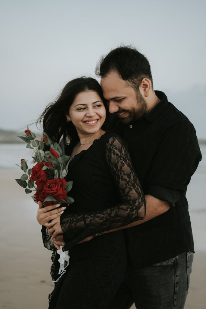 Romantic pre-wedding couple walking along the peaceful shoreline of Diu during an evening beach photoshoot.